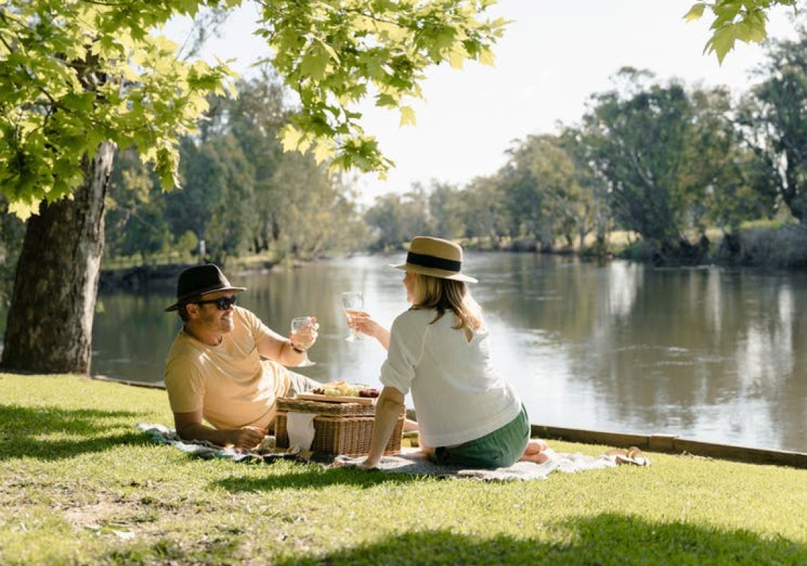 Couple enjoying a picnic along the banks of the Murray River Howlong in Howlong, The Murray